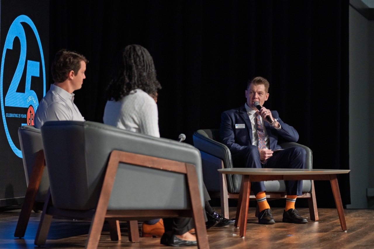 Ryan Penley speaking into a microphone during a panel discussion